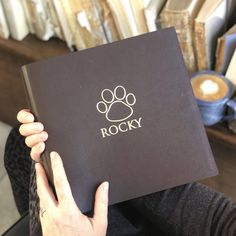 a person holding up a book with a dog's paw on it