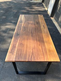 a wooden table sitting on top of a sidewalk