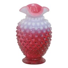 a red and white glass vase sitting on top of a table