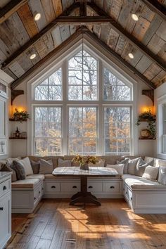 a living room filled with lots of furniture under a large window covered in wood planks