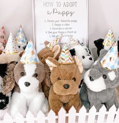 several stuffed animals wearing party hats in front of a sign