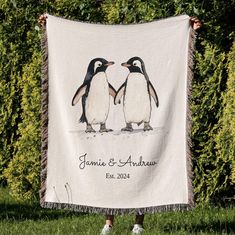 a couple of penguins standing next to each other on top of a grass covered field