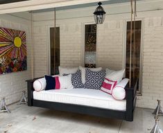 a white couch sitting on top of a wooden floor next to a wall with windows