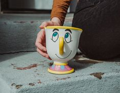 a person holding a cup with a face painted on it