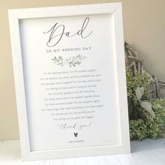 a white frame with an inscription on it next to flowers and a teddy bear in the background