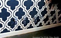 the wall is decorated with black and white tiles, which are accented with glass knobs