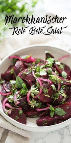 a white bowl filled with sliced beets and green garnish on top of a table