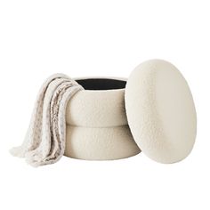 a white round container with a blanket on top