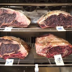 three racks of raw meat sitting in an oven