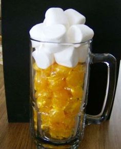 a mug filled with marshmallows on top of a table