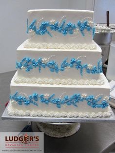 a three tiered cake with blue flowers on it