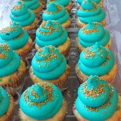 there are many cupcakes with blue frosting and gold sprinkles