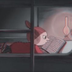 a woman laying on top of a bed next to a window with a book in her hand