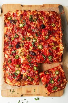 a square pizza sitting on top of a wooden cutting board