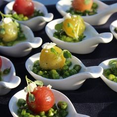 small white bowls filled with different types of food on top of a blue table cloth