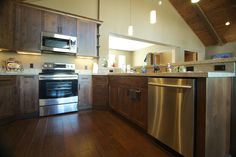 a kitchen with wood floors and stainless steel appliances