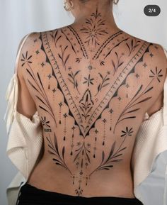 the back of a woman's body with tattoos on her upper and lower back