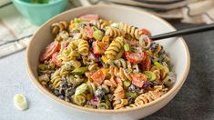 a bowl filled with pasta salad on top of a table