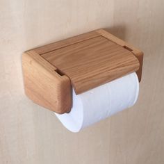 a wooden toilet paper holder on the wall