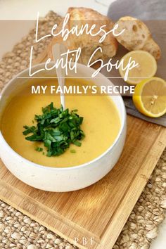 a white bowl filled with soup on top of a cutting board next to sliced lemons