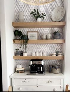 a coffee maker on top of a white dresser next to shelves filled with pots and pans