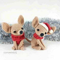 two small crocheted dogs wearing red and white scarfs next to a christmas tree