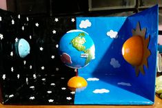 an earth and sun model sitting on top of a wooden table