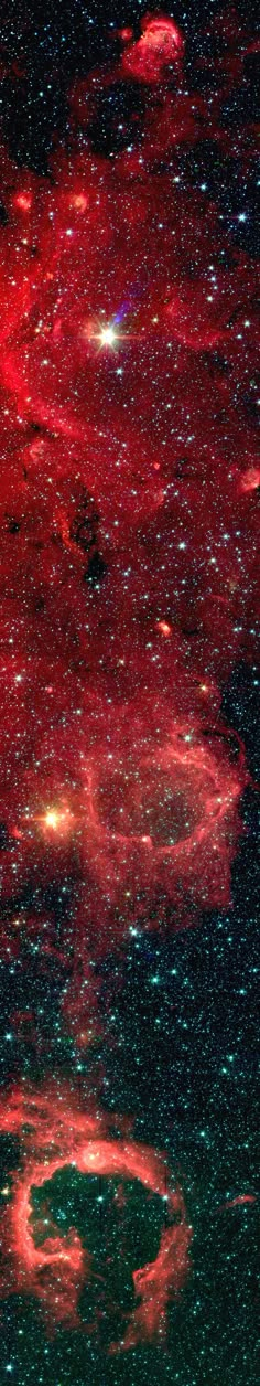 an image of some red and green stars in the night sky, as seen from space