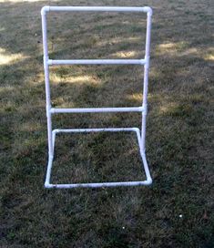 a white ladder sitting on top of a lush green field