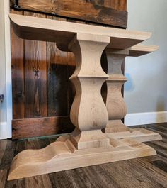 a wooden table sitting on top of a hard wood floor next to a wall and door