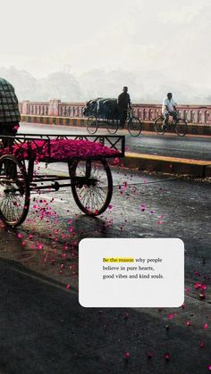 a man riding on the back of a horse drawn carriage down a street next to flowers