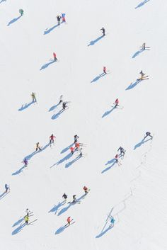 an aerial view of people skiing down a hill