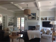 a living room filled with furniture and a flat screen tv mounted on the wall above a fire place