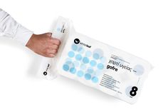 a person holding a pack of wipes on top of a white surface with blue circles