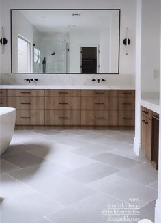 a large bathroom with two sinks and a bathtub in the middle of the room