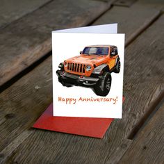 an orange jeep birthday card on top of a wooden table