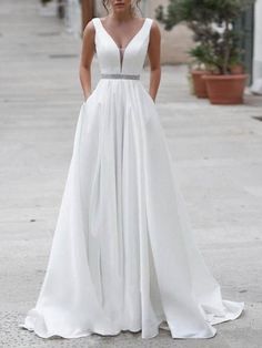 a woman in a white dress standing on the street