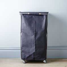 a black suitcase sitting on top of a hard wood floor next to a white wall