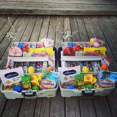 three plastic storage containers filled with different types of toys and food items sitting on a wooden floor