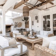 a living room filled with white furniture and lots of wood beams on top of it