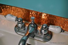 two faucets are connected to the side of a sink with copper foil on it