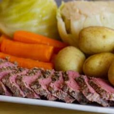 a white plate topped with meat, potatoes and carrots