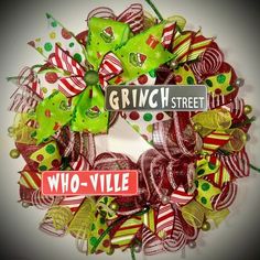 a christmas wreath with green and red bows, street name sign and candy canes