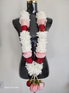 a mannequin with flowers on it's back and white petals around the neck