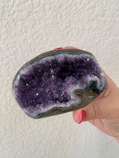 a hand holding a purple and white rock