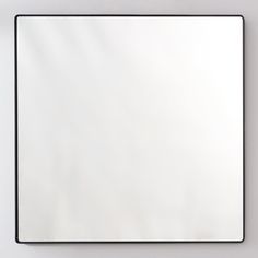 a square mirror mounted to the side of a wall