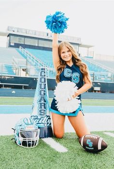 a cheerleader posing on the football field with her pom poms in hand