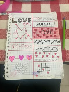 a notebook with writing on it sitting on a checkered table cloth next to other items