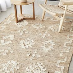 an area rug with two chairs and a table