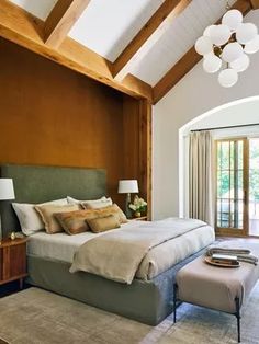 a bedroom with a large bed and wooden ceiling